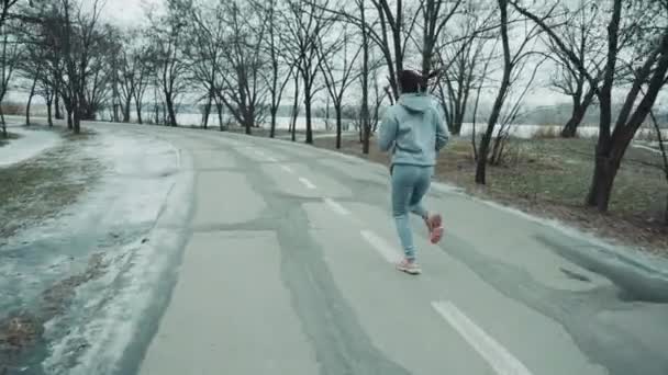 겨울에 길을 달리는 암컷 조깅하는 사람 — 비디오