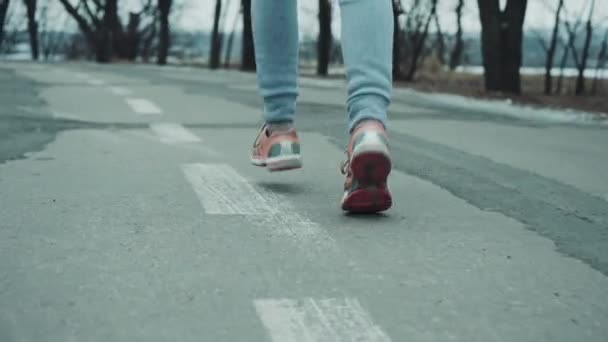 Füße von Joggerin laufen im Winter auf Straße — Stockvideo
