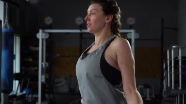 Боксер женского пола разогревается скакалкой в спортзале — стоковое видео