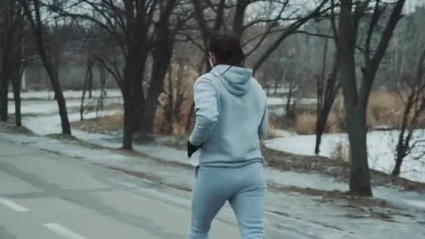 Frau joggt im Winter auf leerer Straße — Stockvideo