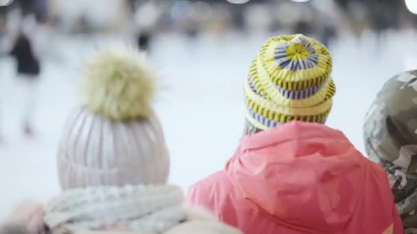 Niños balanceándose cerca de pista de hielo en el mercado de vacaciones — Vídeo de stock