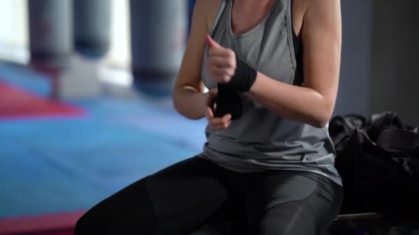 Kämpferin wickelt Handgelenke im Fitnessstudio mit Bandagen — Stockvideo