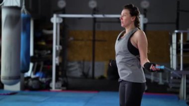 Formda kadın spor salonunda ip atlamakla egzersiz yapıyor.