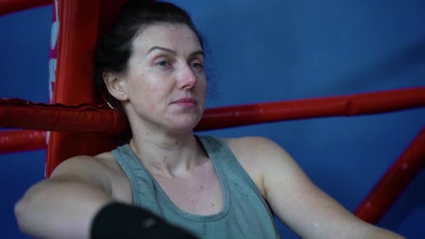 Kobieta bokser pokryte potem relaks na ringu bokserskim — Wideo stockowe