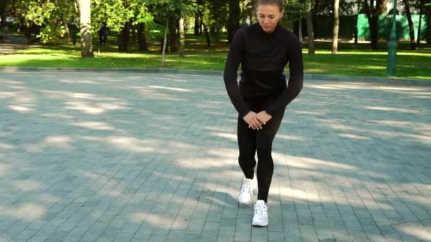 Fit mujer estirando las piernas antes de correr en el parque — Vídeos de Stock