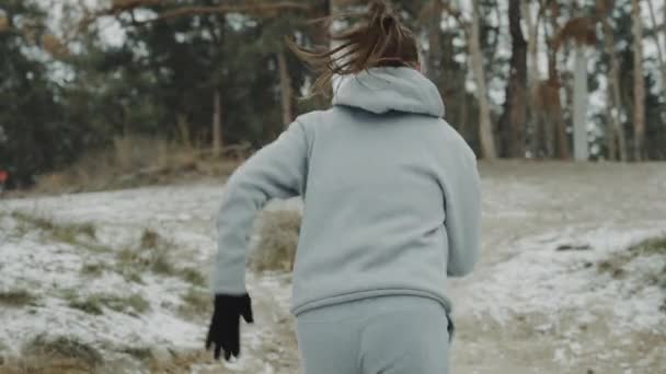 Fit mujer corriendo por la colina nevada — Vídeo de stock