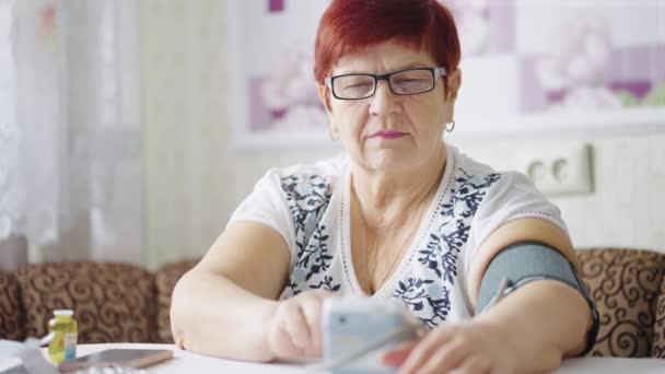 Femeia în vârstă care măsoară tensiunea arterială — Videoclip de stoc