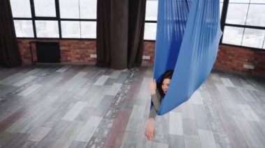 Sinek yoga sınıfında hamakta sallanan bir kadın