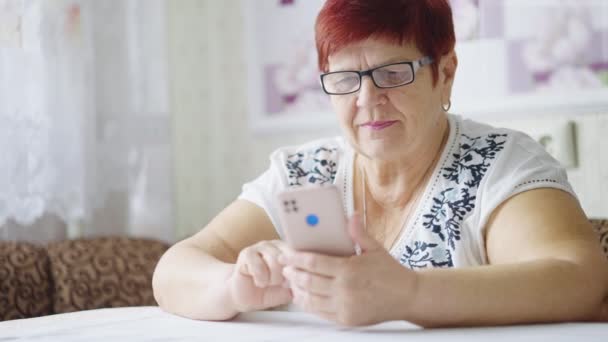 Senior vrouw vegen foto 's op smartphone — Stockvideo