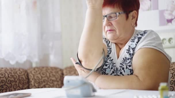 Seniorin überprüft Blutdruck mit digitalem Gerät — Stockvideo