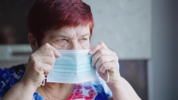 Senior woman staying safe and putting on medical mask — Stock Video