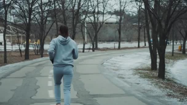 Aktiv kvinna jogga på väg på vintern — Stockvideo