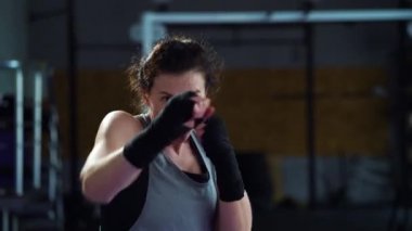 Kadın gölgesi spor salonunda kavga ediyor ve kameraya bakıyor.