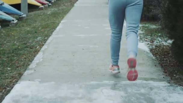 Повільний рух жіночих ніг, що працюють на прогулянці взимку — стокове відео