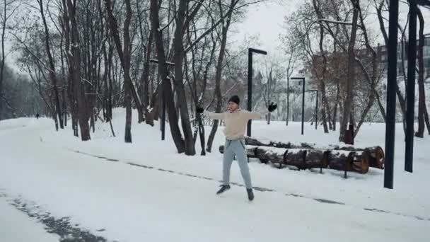 Uomo che salta sulla neve nel parco invernale — Video Stock