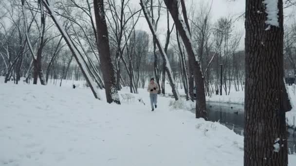 Jogger si avvicina alla telecamera mentre corre lungo il fiume — Video Stock