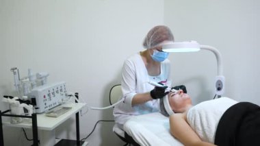 Güzellik uzmanı derin yüz soyma için ultrason cihazı kullanıyor.