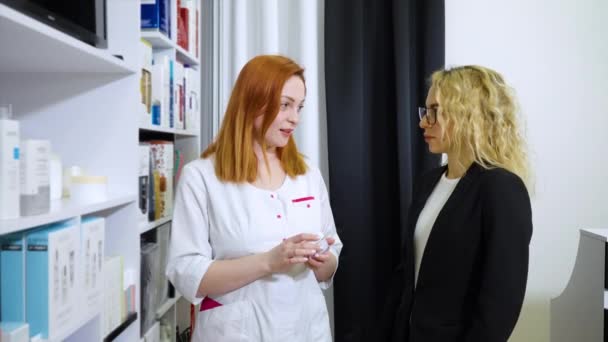 Cosmetologist giving advice on skin care creams to customer — Stock Video