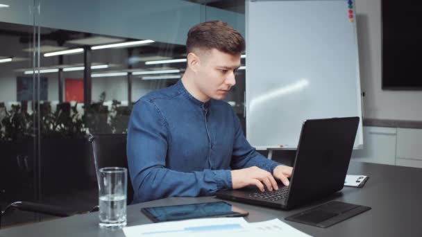 オフィスのノートパソコンに入力するビジネスマン — ストック動画