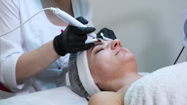 Ultradźwiękowy peeling skóry twarzy klienta kliniki kosmetycznej — Wideo stockowe