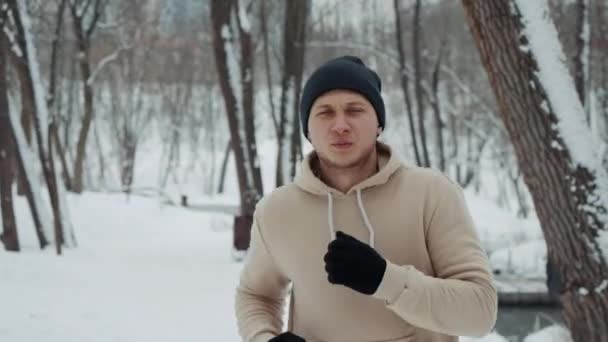 Man ademt stoom uit tijdens het joggen buiten in de winter — Stockvideo