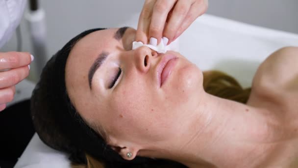Mãos de esteticista limpeza rosto da mulher no spa de bem-estar — Vídeo de Stock