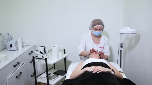 Frau bekommt Anti-Falten-Gesichtsmassage in Schönheitsklinik — Stockvideo