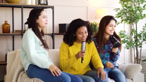 Colegas de quarto multirraciais cantando karaoke em casa — Vídeo de Stock