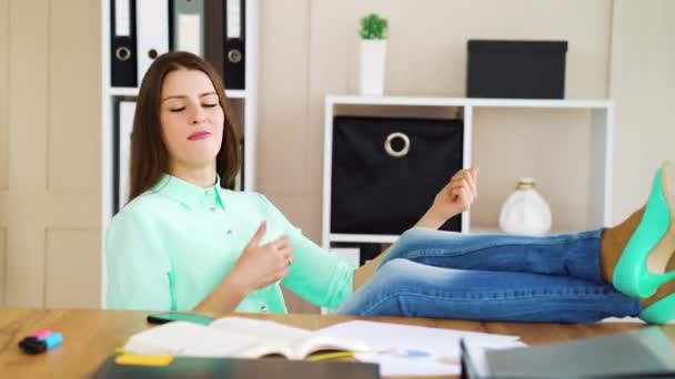 Mujer tocando guitarra imaginaria mientras se relaja en la oficina — Vídeos de Stock