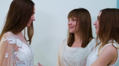 Gelin, gelinliğini kuaförde arkadaşlarına gösteriyor.