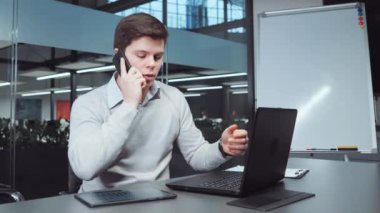 Analist istatistikleri kontrol ediyor ve telefonla konuşuyor