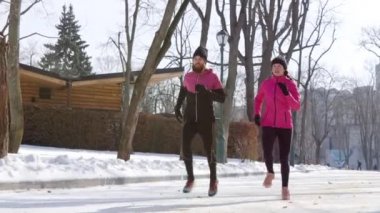 Fit çift kış parkında birlikte koşuyor.