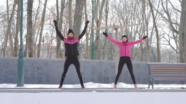 Fit duet skoków i ćwiczeń razem w parku zimowym — Wideo stockowe