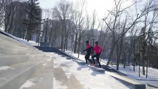 Ajuste pareja trotando en la escalera en invierno — Vídeos de Stock