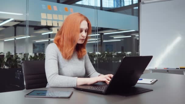 Rött hår kvinna skriva rapport i kontor — Stockvideo
