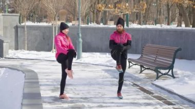 Arkadaşlar ısınıyor ve kış parkında yumruk tokuşturuyorlar.