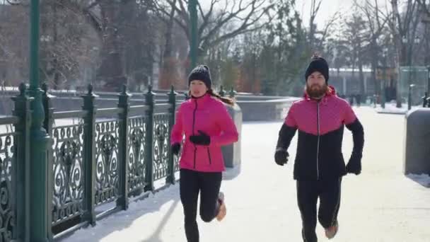 Sportowa para jogging na moście w zimie — Wideo stockowe