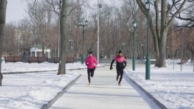 Kış parkında koşan kadın ve erkek