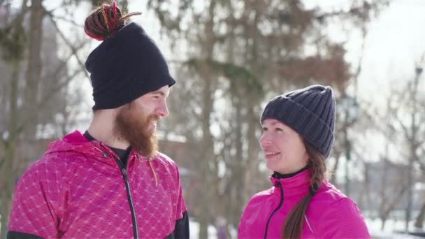 Man och kvinna skrattar åt kameran i vinterparken — Stockvideo