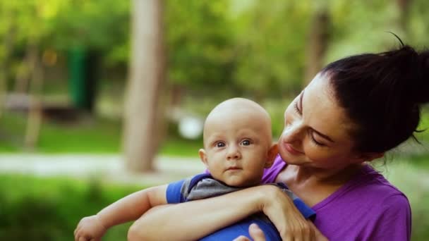 Happy mother with baby in arms posing in park — Stock Video