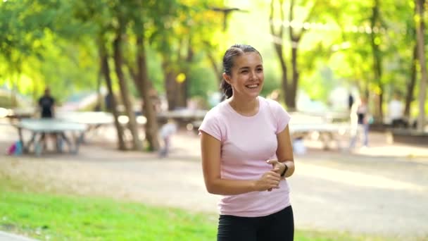 Woman in sportswear laughing in park — Video