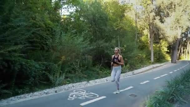 Blonde woman jogging in park in summer — Video Stock