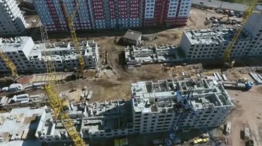 Aerial builders working on roofs of multistory buildings