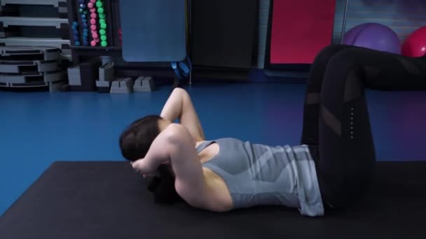 TRXストラップを使用してジムで腹部の練習を行う女性をフィット — ストック動画
