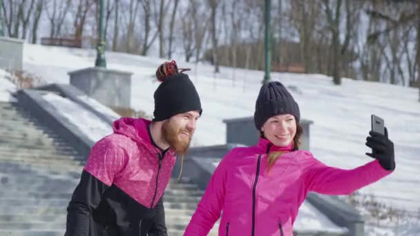 Pár s selfie po cvičení v zimním parku — Stock video