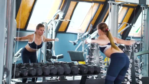 Kobieta ćwiczy z hantlami przed lustrem siłowni — Wideo stockowe