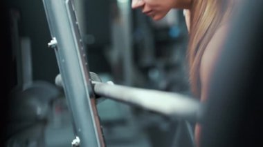 Spor salonunda ağırlık plakası takan bir kadın.