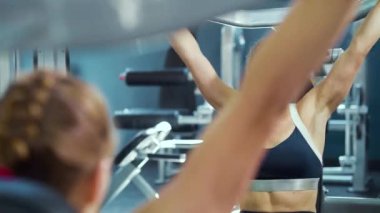 Kadın spor aletlerini kaldırıyor ve zor nefes alıyor.