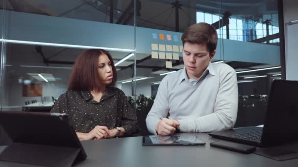 Мультиэтнические бизнес-аналитики проверяют планшет в офисе — стоковое видео