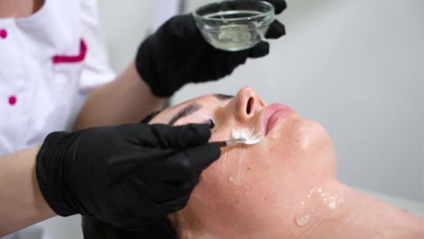 Woman getting emulsion on face in wellness spa — Stock Video